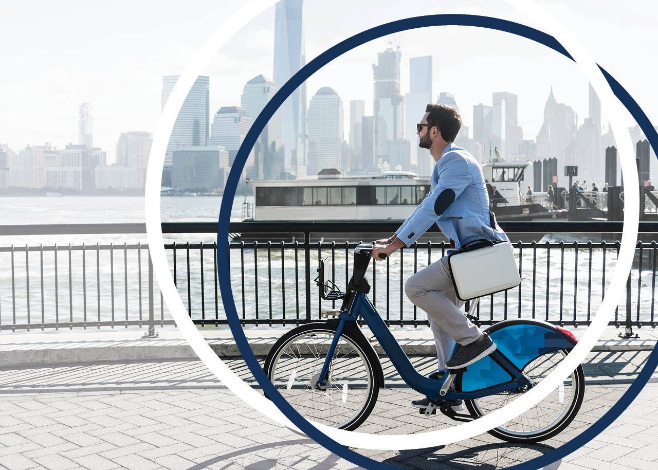 man on bicycle at New Jersey waterfront with view to Manhattan